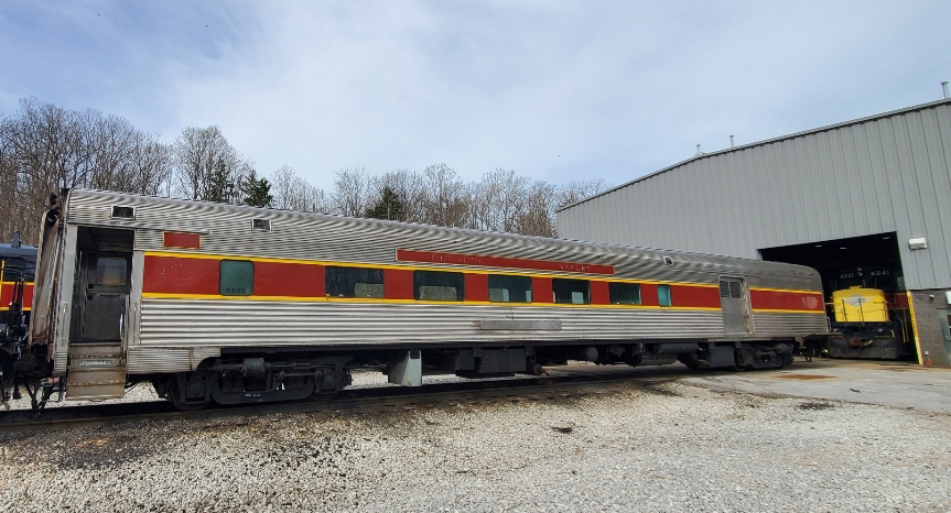 Staiinless steel passenger car with marooon stripe at windows