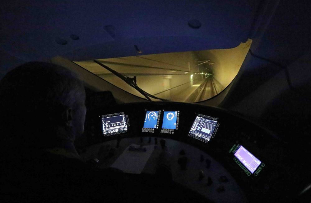 Darkened interior of locomotive cab in tunnel with various video screens 