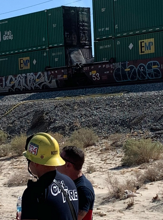 Firemen standing near double-stack container cars