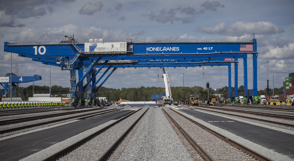 Blue cranes straddling railroad tracks