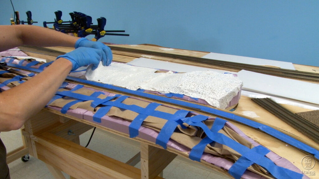 Rene adding plaster cloths to form the terrain on the N scale State Line Route layout