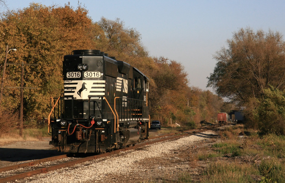 Black locomotive on single-track rail line