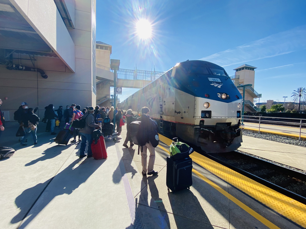 Passengers waiting on platform as passenger train arrives