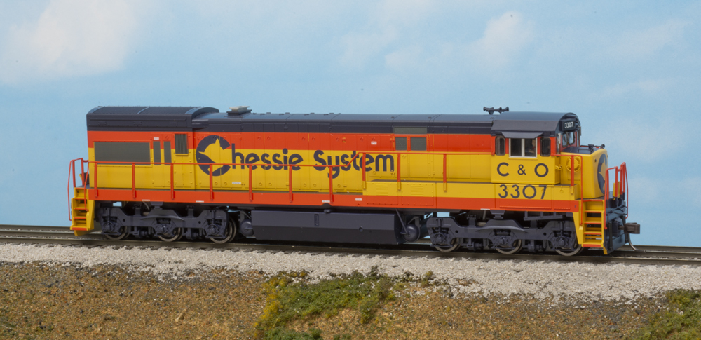 HO scale locomotive painted yellow, blue, and vermillion on scenicked base.