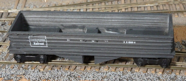 3-D printed HO scale hopper model painted black on scenicked base.