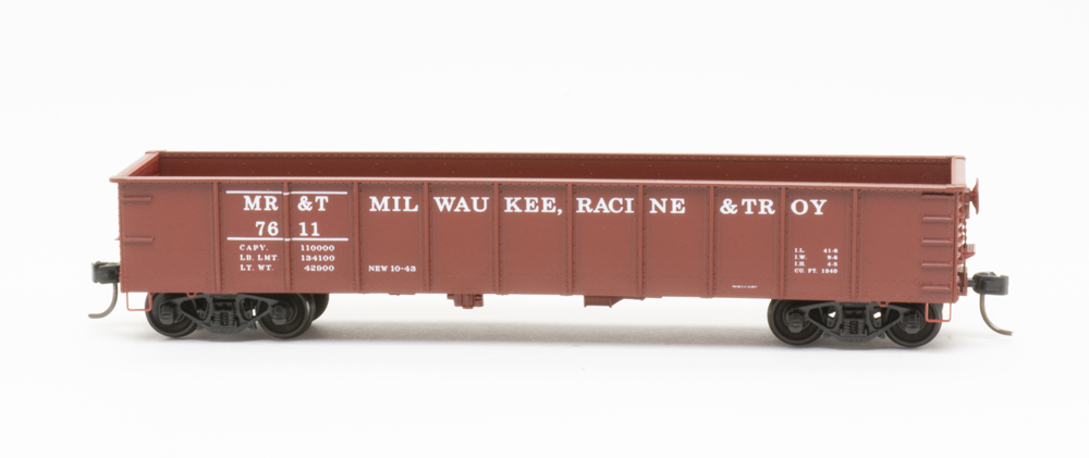 Photo of HO scale gondola painted mineral red with white lettering on white background.