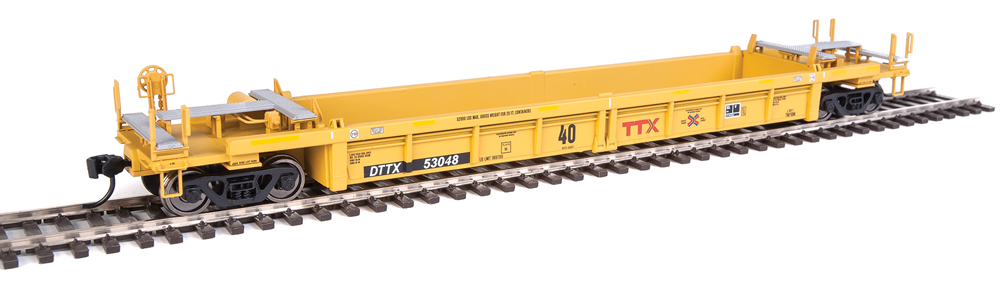 Photo of HO scale well car painted yellow with black, white, and red graphics on section of nickel-silver rail.