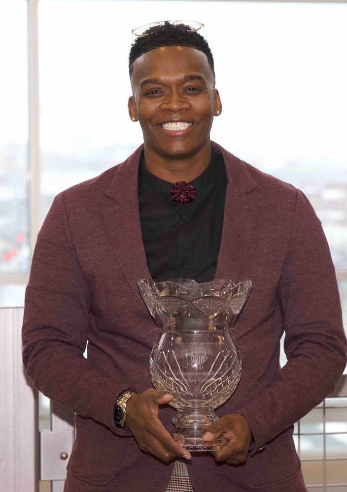 Person in red coat and black shirt holding glass bowl