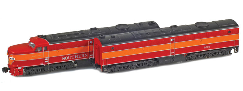 Photo showing Z scale Alco PA-1 and PB-1 diesel locomotives painted red, orange, black, and silver on white background. 