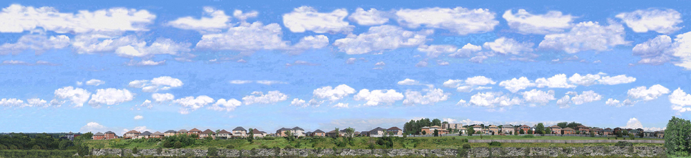 Photo backdrop with suburban buildings, trees, and clouds.