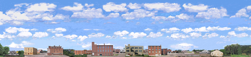 Photo backdrop with modern multi-unit buildings, trees, clouds, and rock wall.