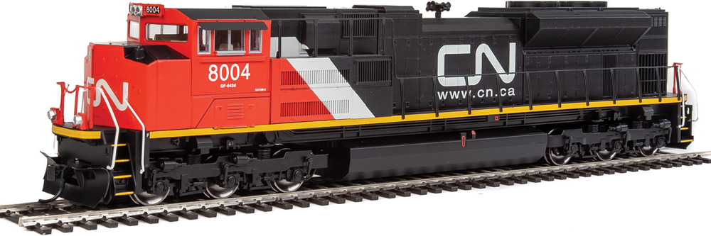 Photo of diesel locomotive painted red, white, and black with yellow sill stripe.