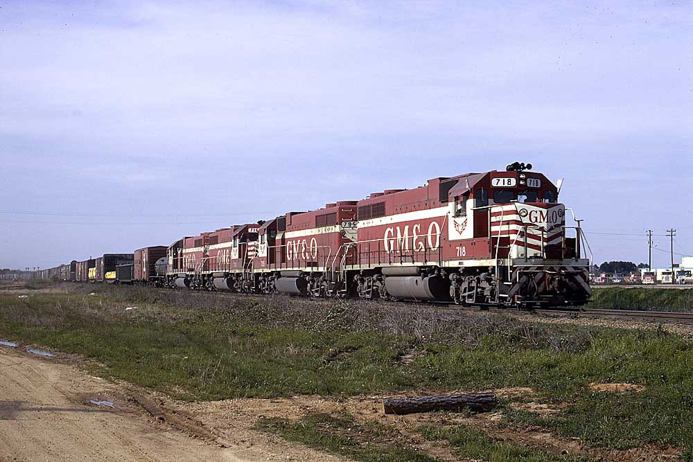 Red and white diesel locomotives with freight train