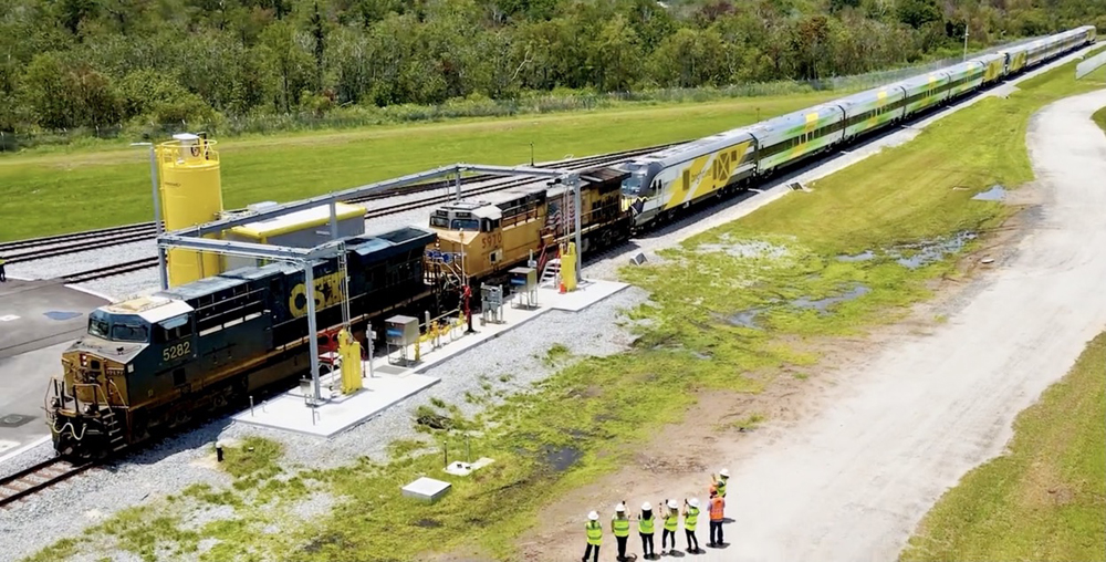 Two freight locomotives pulling two passenger trainsets, including engines