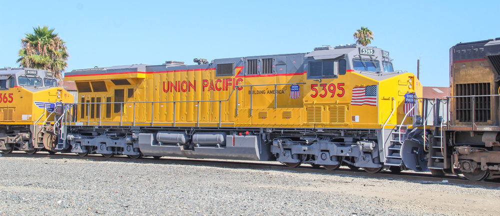 Side view of yellow and gray locomotive with red trim