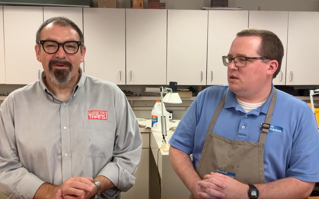 Two men at a counter, talking.