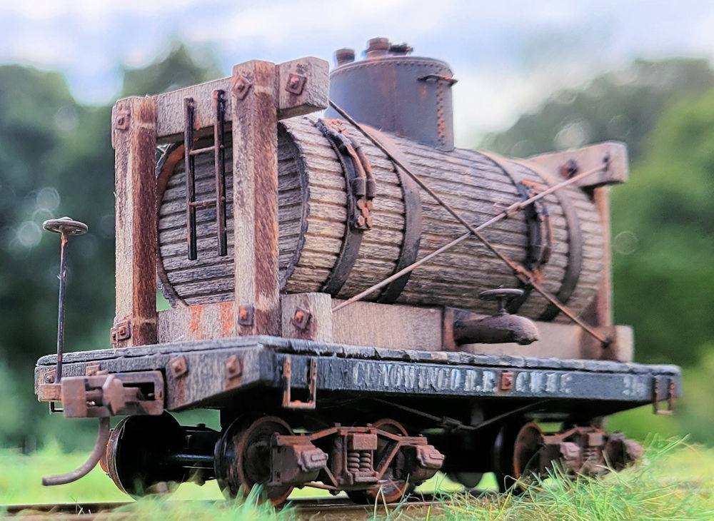 Small wooden tank on short flatcar