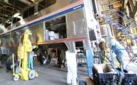 Men working on passenger car in shop