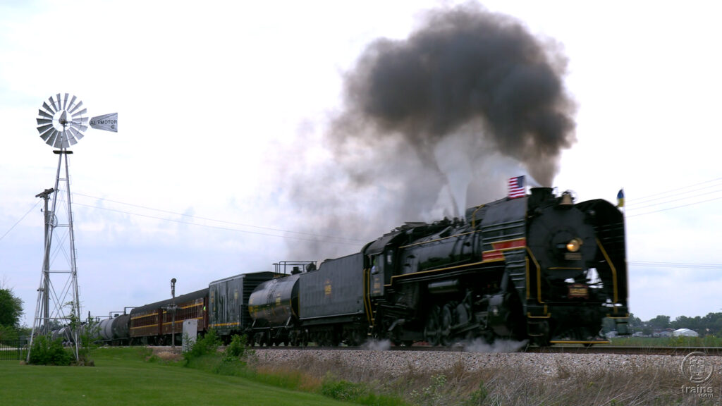 black train on track with a lot of smoke