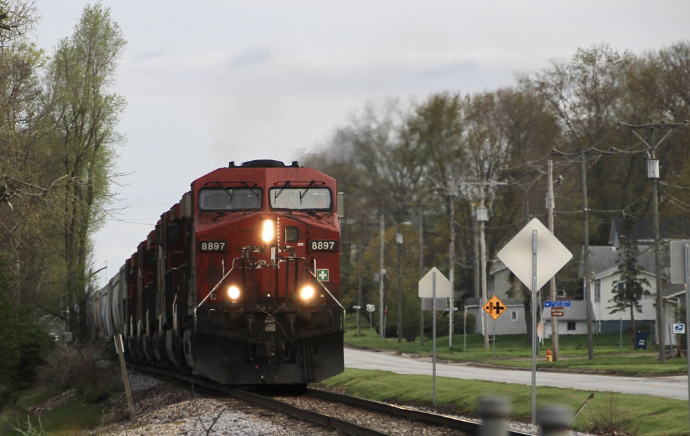 Train with red locomotives passes through small town