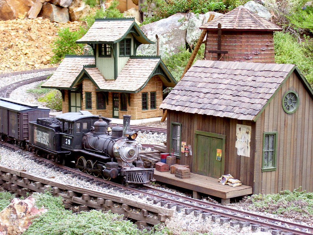 Freelance Colorado narrow-gauge branch line: model steam train approaches buildings