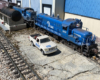 white model truck and blue model diesel locomotive