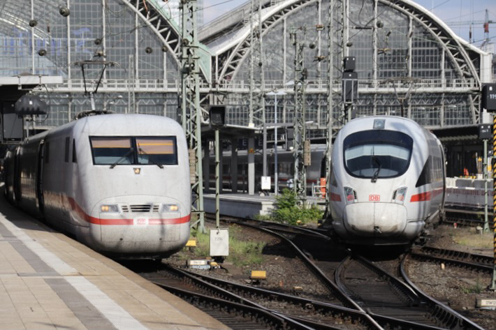 Two white high-speed trains at station
