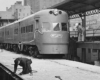 Men check station clearances by streamlined Chicago North Shore & Milwaukee equipment