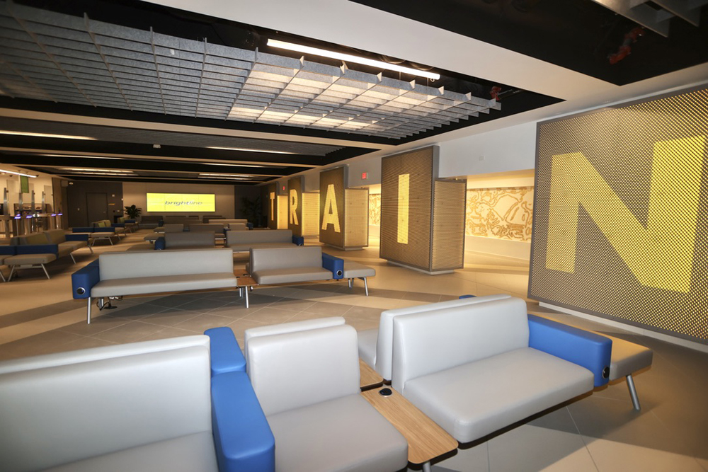 Inside of new passenger station waiting room, featuring large yellow letters spelling out "Train"
