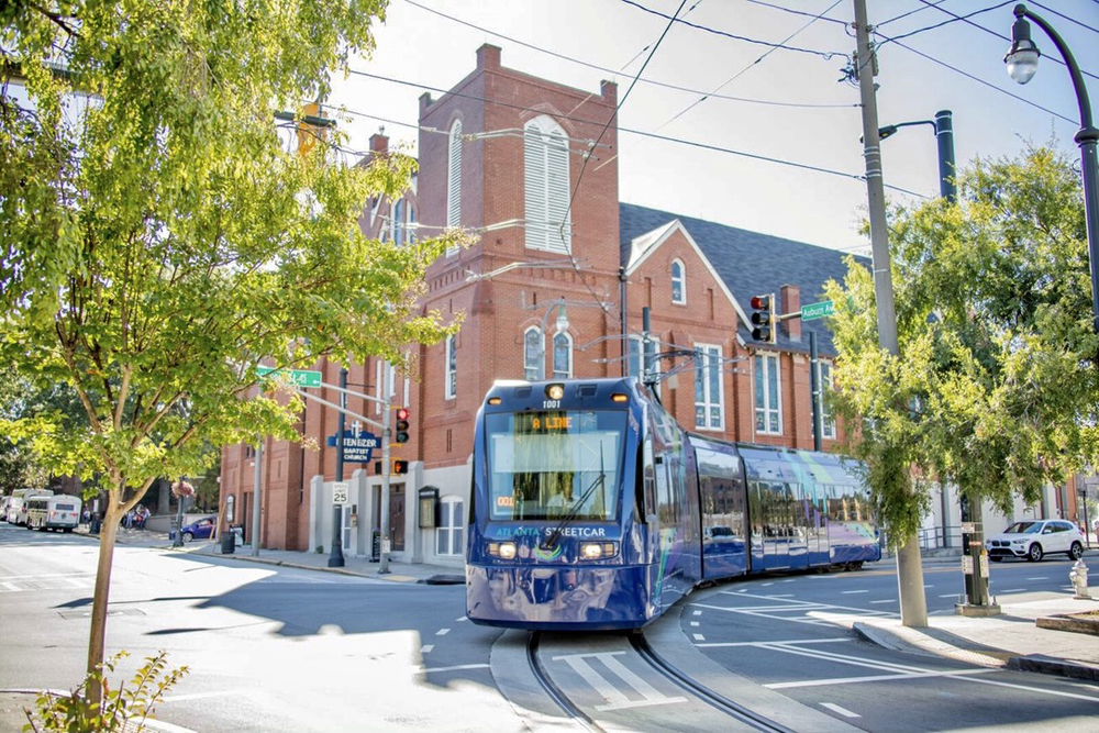 Light rail vehicle rounding curve with brick church in background