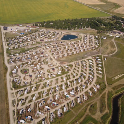 Aerial shot of RV campground next to railroad and passenger train.