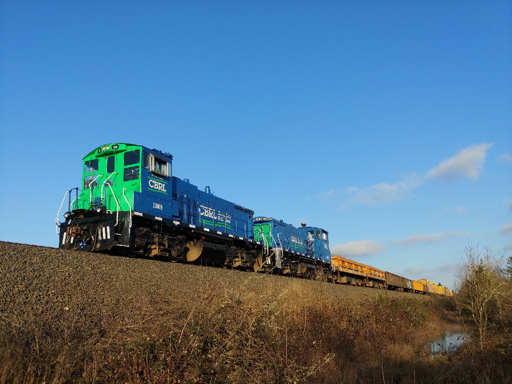 Blue and green switch engines pulling freight train