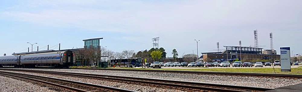 amtrak passenger train at station next to baseball park