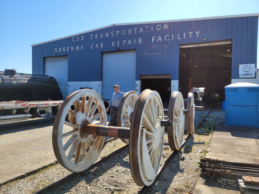 Three sets of steam locomotive driving wheels outside building