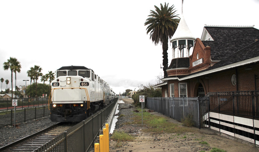 Commuter train next to ornate former station