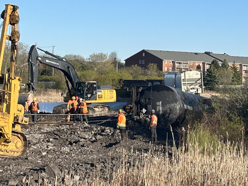 Work crews around derailed tank cars and damaged track