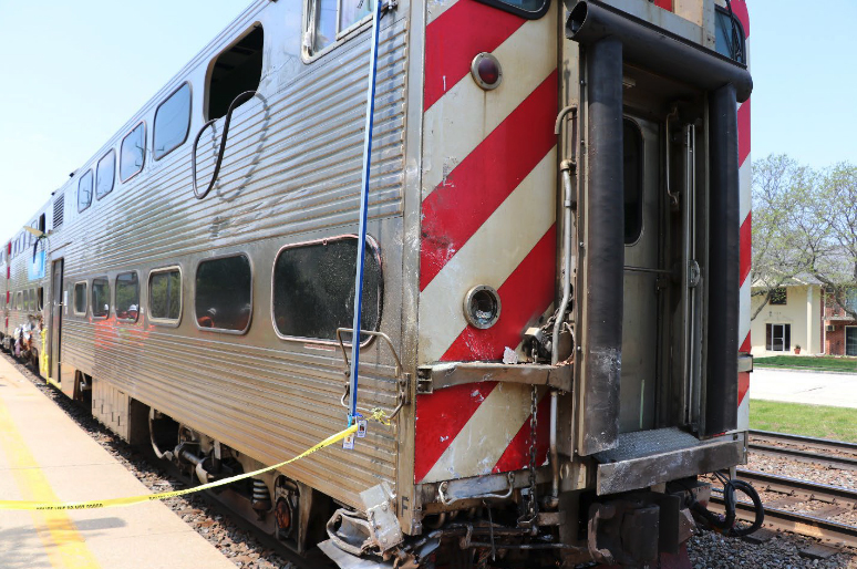 Three-quarter view of damage at the front of commuter rail cab car