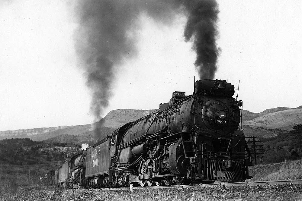 Smoking steam locomotives with freight train in mountains