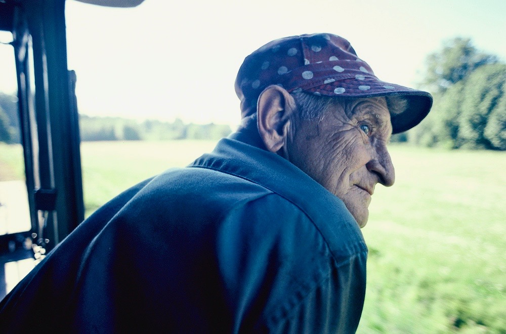 Man in engineer's cap looking out of steam locomotive