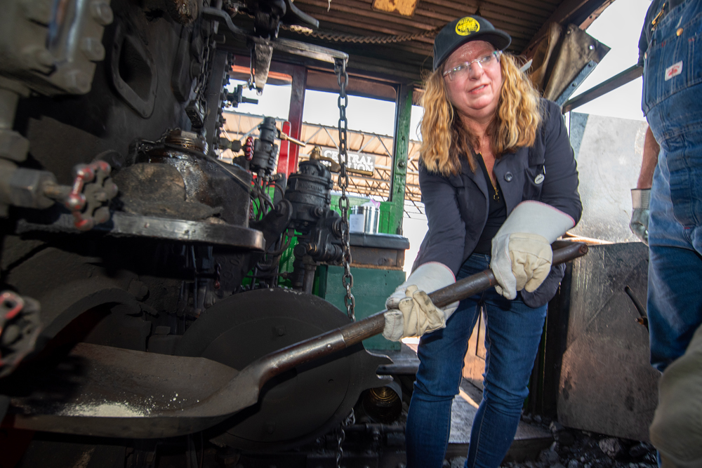 Woman with shovel in cab of steam locomotive