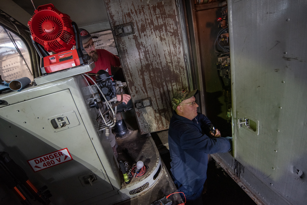 Two men work inside locomotive