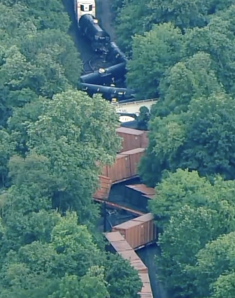 Aerial view of derailed train in heavily wooded area