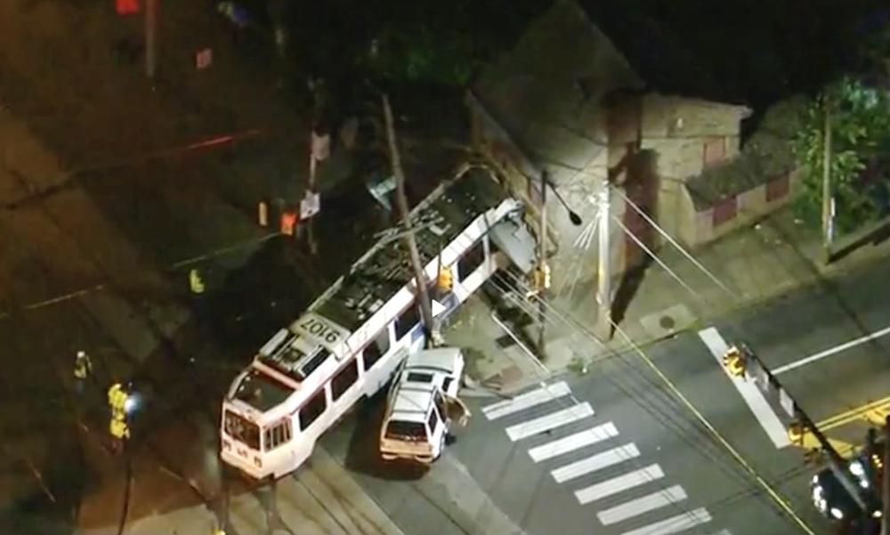 Aerial view of derailed light-rail vehicle with one end inside stone building