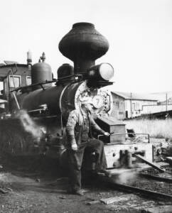 Man poses on front of Argent Lumber steam locomotive