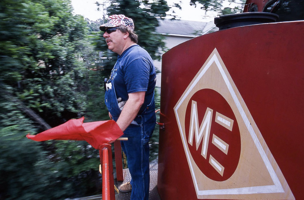 Man with red flag on front of diesel locomotive