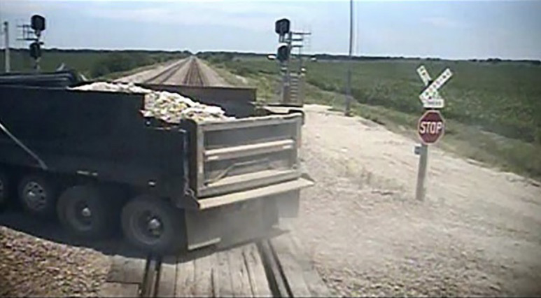 View of back of dump truck on railroad track