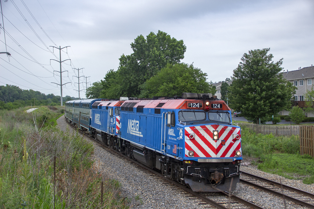 Commuter train with two locomotives under gray skies