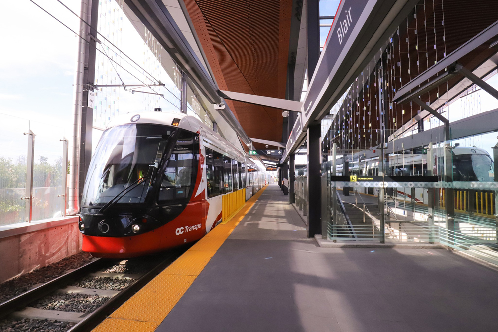 Red and white light rail train in station