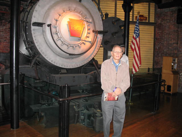 Man standing next to front of steam locomotive
