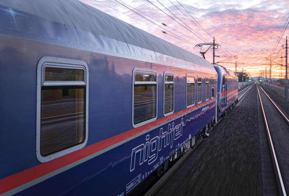 blue and red high-speed train with sunset